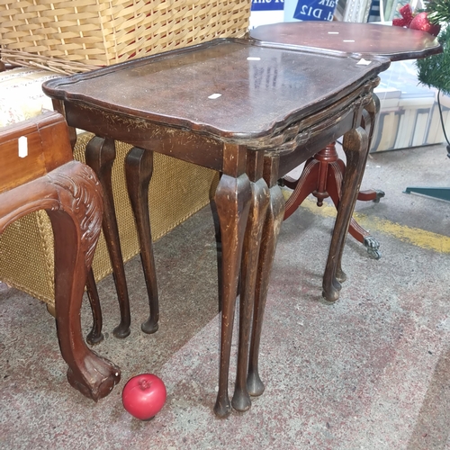 691 - A set of three vintage nesting tables featuring cabriole legs and a pie crust edge.