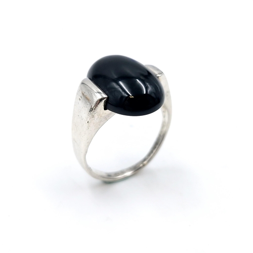 509 - A deep blue large onyx cabochon stone ring set in sterling silver. Ring size - O 1/2. Weight - 5.47 ... 