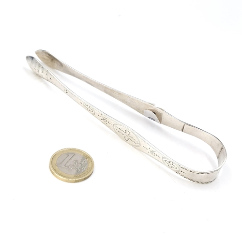 590 - A pair of sterling silver sugar tongs with London hallmarks. Length - 14 cms. Weight - 31.42 grams.