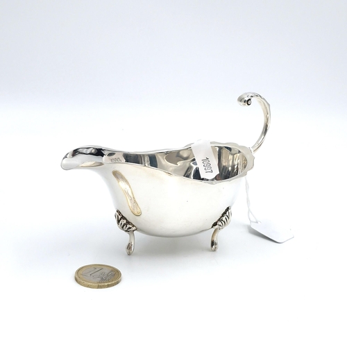 606 - A sterling silver sauce boat with flying C Handle standing on three paw feet hallmarked Birmingham -... 