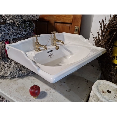 843 - Antique porcelain sink by B.C. Sanitan, featuring brass taps. Classic design with an ornate logo, mo... 