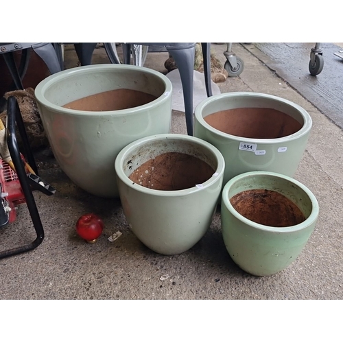 854 - Set of four large green ceramic plant pots, graduated sizes. Durable construction with a sleek desig... 