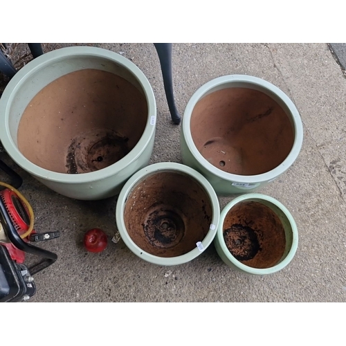 854 - Set of four large green ceramic plant pots, graduated sizes. Durable construction with a sleek desig... 