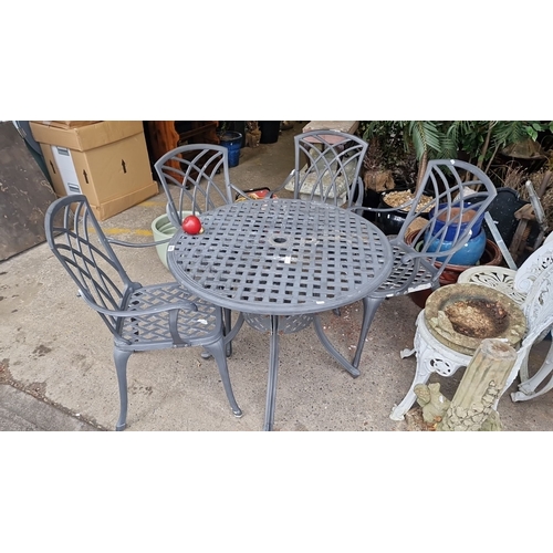 855 - Cast aluminum patio set with round table and four chairs. Features an elegant lattice design.