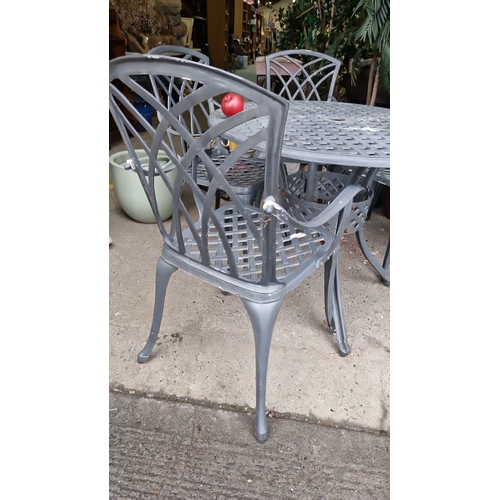 855 - Cast aluminum patio set with round table and four chairs. Features an elegant lattice design.