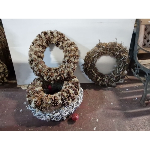 871 - Three rustic wreaths crafted with pinecones and natural moss, showcasing a textured design.