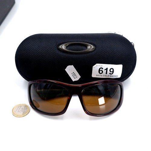 619 - A pair of wrap round Oakley sunglasses. Presented in original pouch.