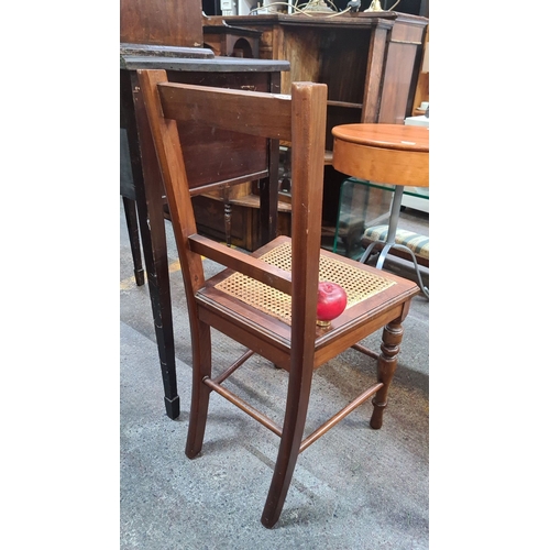 704 - Antique wooden chair with caned seat, turned legs, and ladder back design, crafted from mahogany. Pe... 