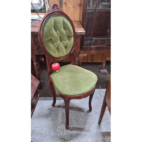 707 - Victorian-style upholstered chair with carved mahogany frame and green tufted fabric, featuring a de... 