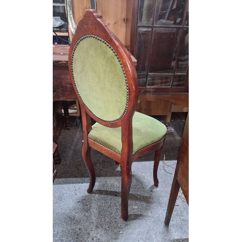 707 - Victorian-style upholstered chair with carved mahogany frame and green tufted fabric, featuring a de... 