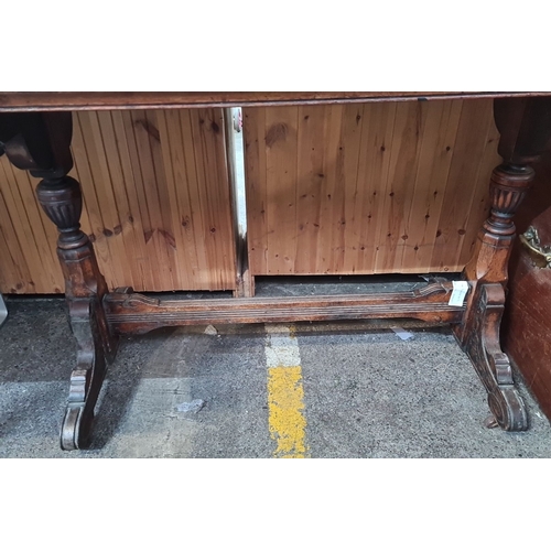 718 - Victorian mahogany writing table with carved trestle legs and inset leather top.