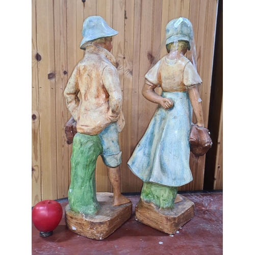 724 - Hand-painted large plaster figurines of a boy and girl, each holding shoes. Vintage style, from mid-... 