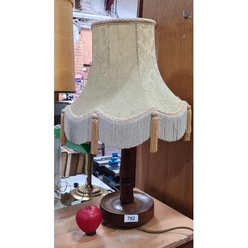 762 - Vintage turned wood table lamp with a patterned fabric shade and tassel fringe. Features a dark wood... 