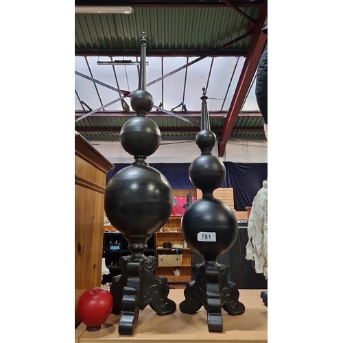 781 - Pair of large black finials with ornate bases, featuring a tiered spherical design and pointed tops.... 