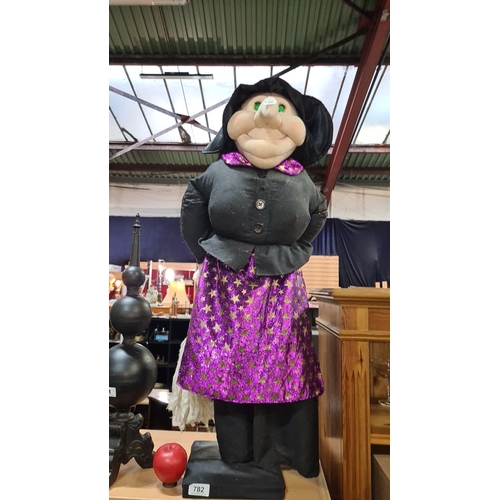 782 - A large witch with black and purple star-patterned attire. Plush construction, featuring a large nos... 