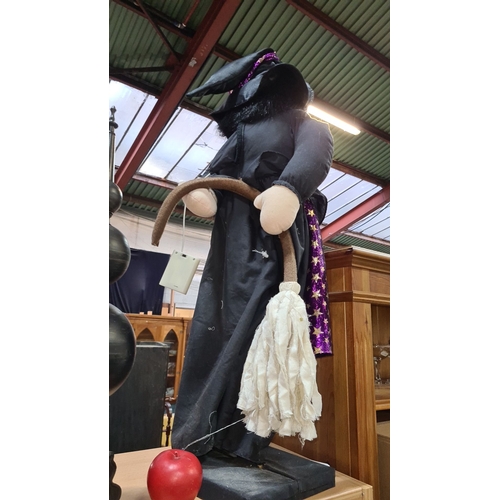 782 - A large witch with black and purple star-patterned attire. Plush construction, featuring a large nos... 