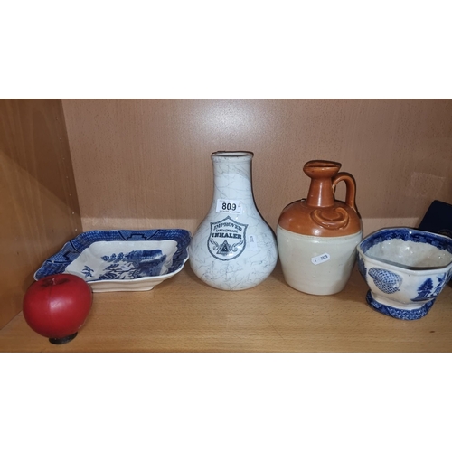 809 - Collection of earthenware items includes unique blue and white ceramics and a brown-handled jug.