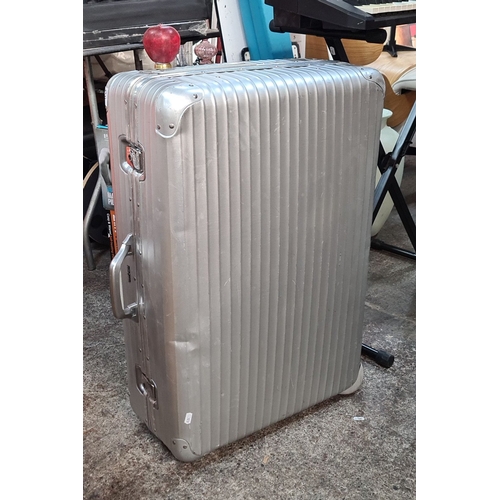 1127 - A Rimowa Aluminum Topas suitcase features a ribbed design, dual handles, and an integrated lock syst... 