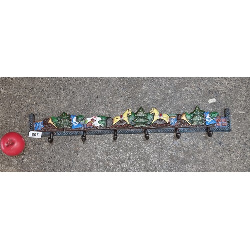 807 - A Festive themed Cast iron coat rack hand-painted with a festive winter scene featuring horses, tree... 