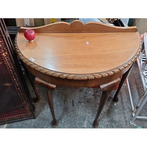 1130 - An Oak demilune console table with carved edge detail and cabriole legs.