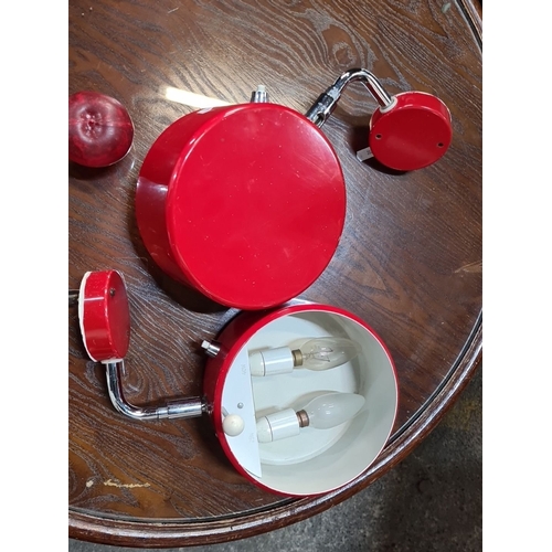 1135 - Pair of vintage red metal wall sconces with adjustable chrome arms and dual bulb holders. Mid-centur... 