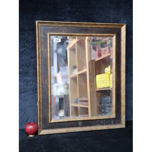 945 - A beautiful gilded and black framed wall hanging mirror. 
MM: 55cm x 65cm.