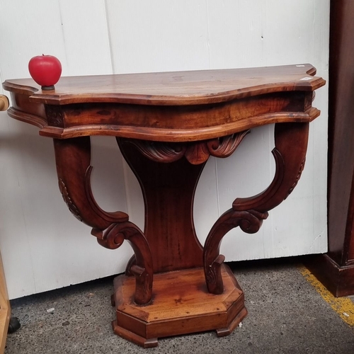 1243 - A very handsome Victorian mahogany console table with intricately carved scroll legs and a shaped to... 