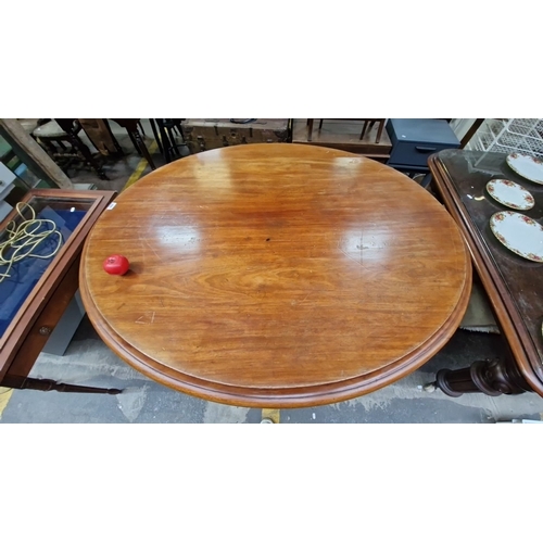 1360 - Star lot : A fabulous round Gold Mahogany dining table with a carved pedestal base, showcasing a ric... 