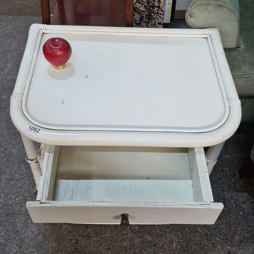 1394 - A White rattan side table with a single drawer and open shelf, featuring a curved rectangular design... 