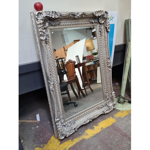 1181 - Star Lot : A large ornate silver gilt wall mounted mirror. Features intricate leaf and floral detail... 