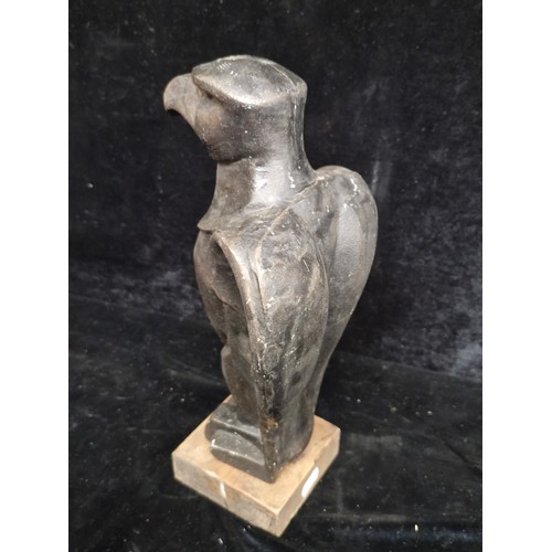 199 - A heavy cast metal statue of a poised eagle  After Klimt, mounted on a wooden plinth base.