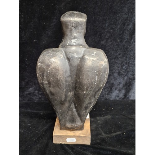 199 - A heavy cast metal statue of a poised eagle  After Klimt, mounted on a wooden plinth base.