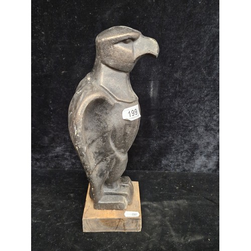 199 - A heavy cast metal statue of a poised eagle  After Klimt, mounted on a wooden plinth base.