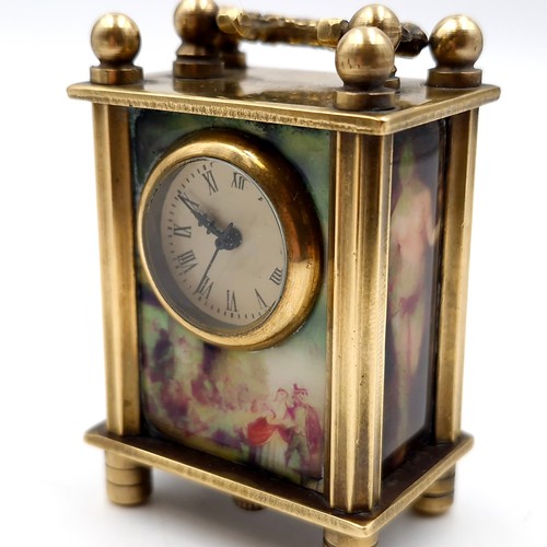 9 - Star Lot : An antique miniature vintage brass carriage clock with handle with three panels depicting... 