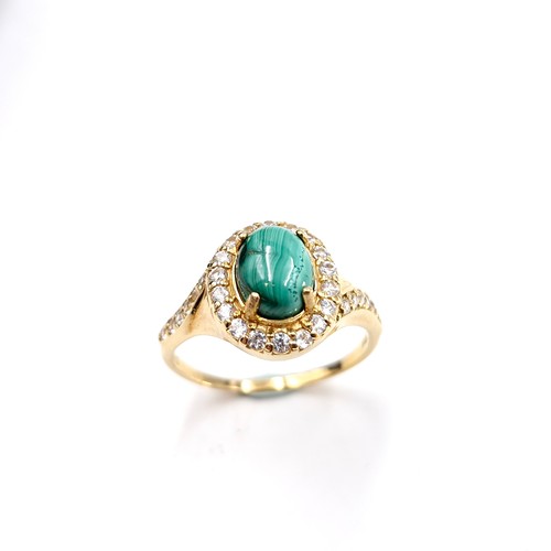 548 - A nine carat gold plated malachite cabochon stone ring with gem set mount and surround. Size - W. We... 