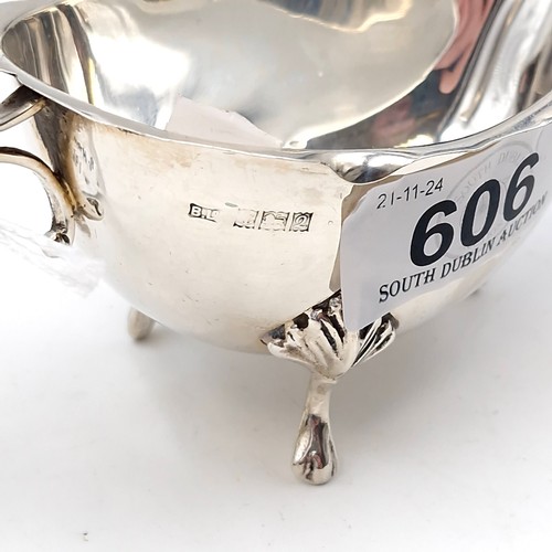 606 - A sterling silver sauce boat with flying C Handle standing on three paw feet hallmarked Birmingham -... 