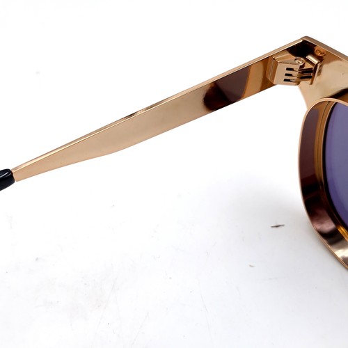 620 - A pair of Joshua Kane sunglasses with gilt metal frames. Presented in original case & box.