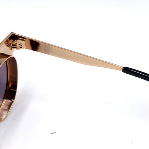 620 - A pair of Joshua Kane sunglasses with gilt metal frames. Presented in original case & box.