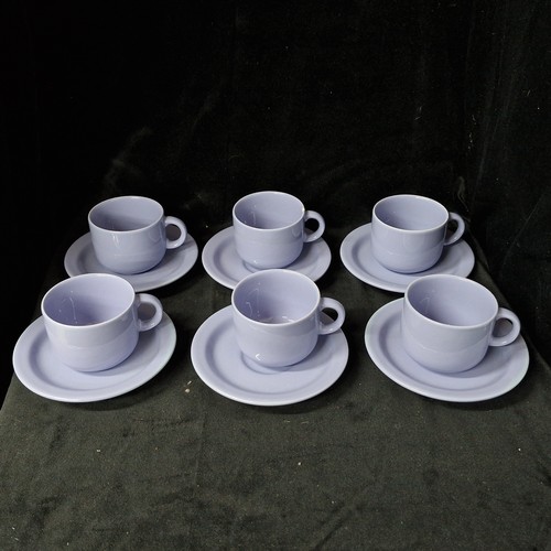 1032 - A box containing ceramic cups and saucers. Includes six cups and six saucers. Features a soft lilac ... 