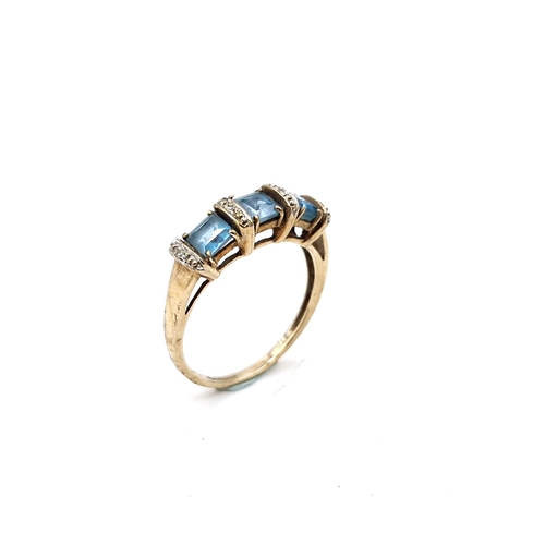 21 - Star Lot : A very pretty nine carat gold (375) three stone blue topaz and diamond ring. Ring size - ... 