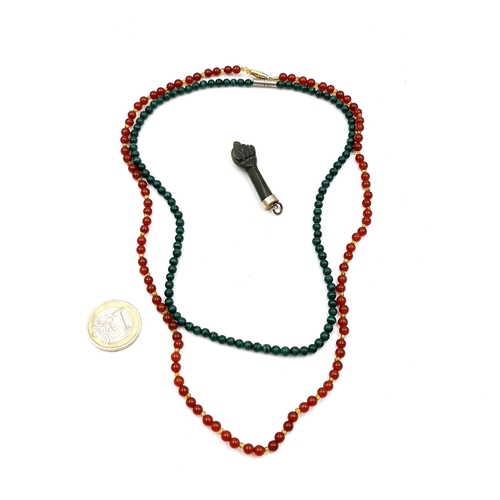 508 - A jade pendant in the form a clenched fist together with two jade necklaces cold to the touc  with t... 