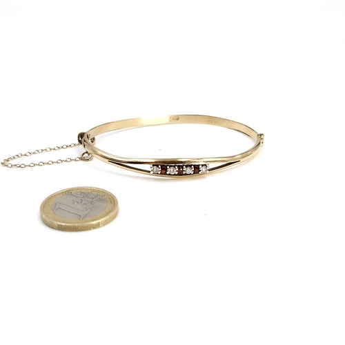 525 - A gold core bracelet with gemstone mount and safety chain. Weight - 9 grams. Boxed.