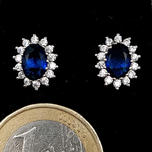 548 - A pair of blue sapphire sterling silver stud earrings with gemstone surround. Old new stock - never ... 