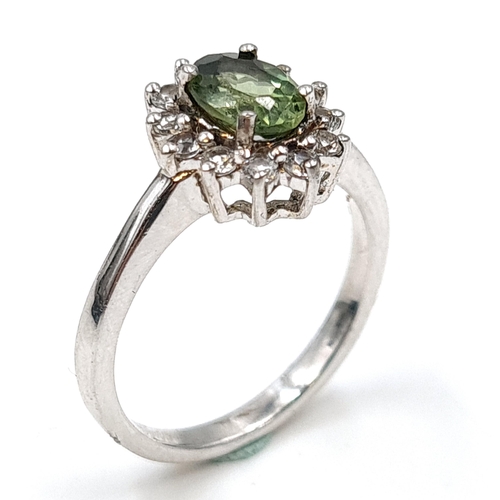 557 - A diopside stone ring with gemstone surround set in sterling silver. Size - M. Weight - 2.67 grams. ... 