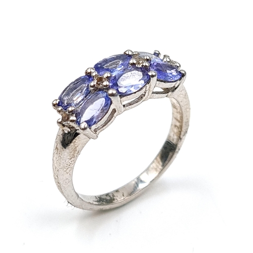 558 - A good example of a three stone tanzanite ring set in sterling silver. Size - M 1/2. Weight - 2.7 gr... 