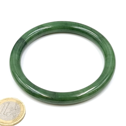 561 - A genuine jade bangle with internal dimensions of 6.5 cms diameter. Weight - 45.7 grams. Boxed. Cold... 