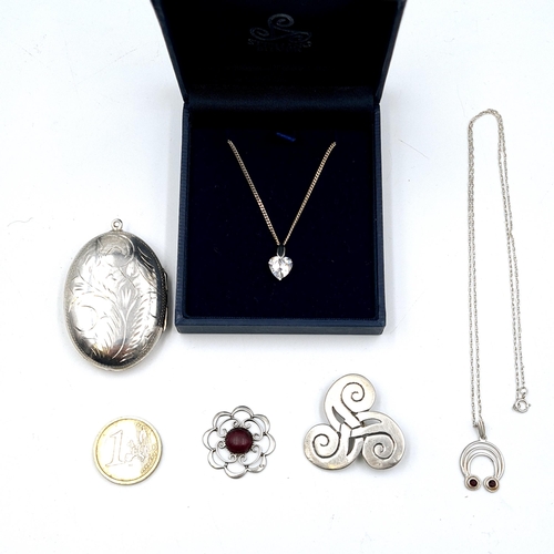 571 - A collection of silver items, A large silver locket pendant together with three Irish items and a ge... 