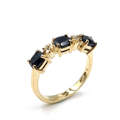 588 - Star Lot : A nine carat gold three stone large sapphire & diamond ring. Size - N 1/2. Weight - 2.75 ... 