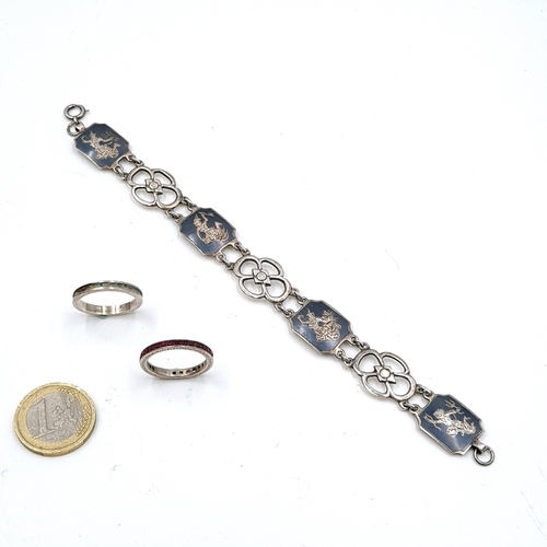 591 - Two silver gem set eternity rings. Size - N. Together with a sterling silver Siamese bracelet. Weigh... 