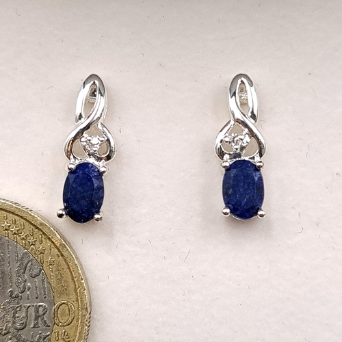 608 - A pair of sapphire stud earrings. Weight - 1.8 grams. Information leaflet enclosed. Boxed. Tests as ... 